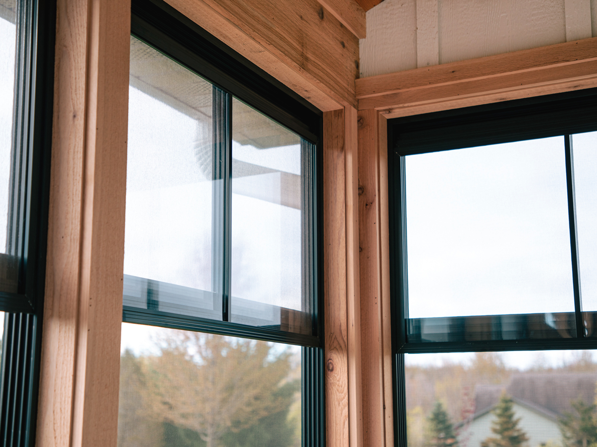 Black Porch Conversions window tracks with vinyl panels stacked toward the top and screens exposed below