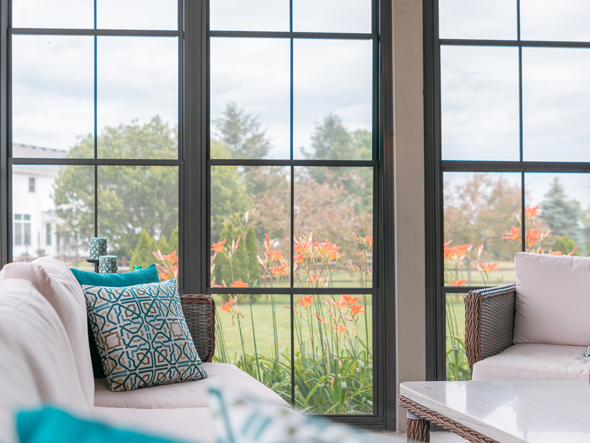 Interior view of black-framed Porch Conversions windows showing the individual panels and horizontal rails